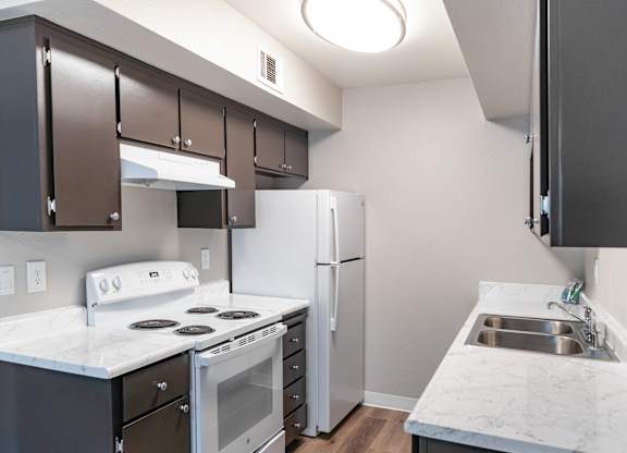 A kitchen with a white counter top and a white stove top oven.