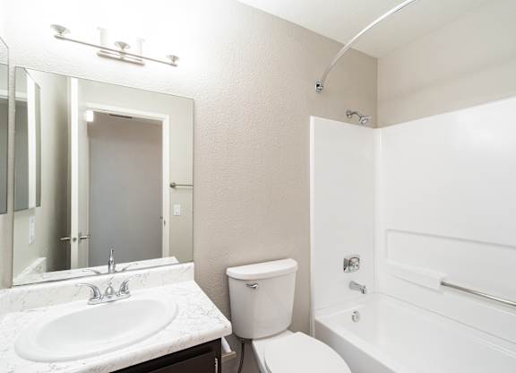 A white bathroom with a sink, toilet, and bathtub.