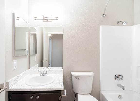 A white toilet sits next to a sink in a bathroom.