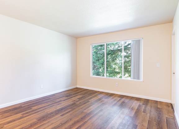 Empty room with wooden floors and a window.