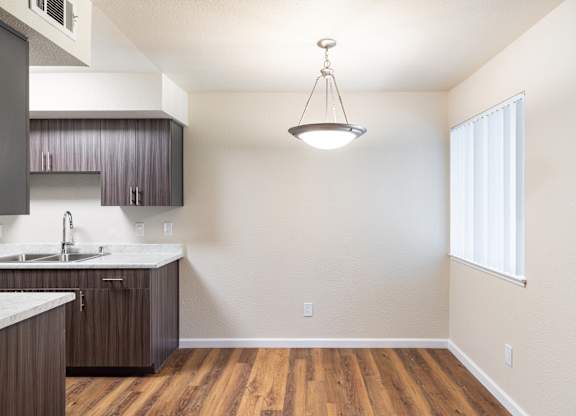 A kitchen with wooden floors and a white countertop.