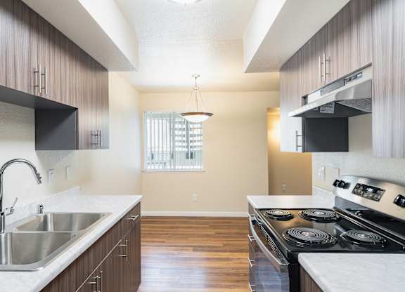 A kitchen with a stove top oven and a sink.