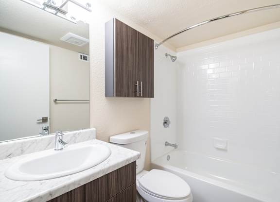 A white sink is on a marble countertop in a bathroom.