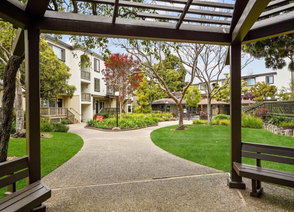a view of a courtyard with benches and buildings