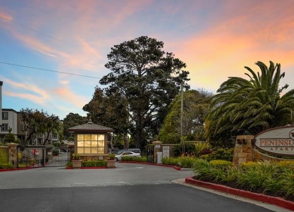 a city entrance with a sign that says Peninsula Pines Apartments