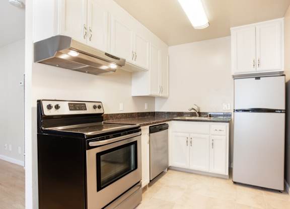 A kitchen with a black stove top oven and white cabinets.