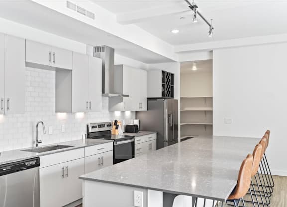 A modern kitchen with white cabinets and appliances. at Paperbox Lofts, Utah, 84101