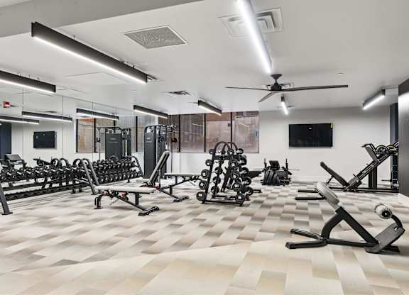 A spacious gym with a variety of equipment and a checkered floor. at Brickside Heights, Utah, 84106