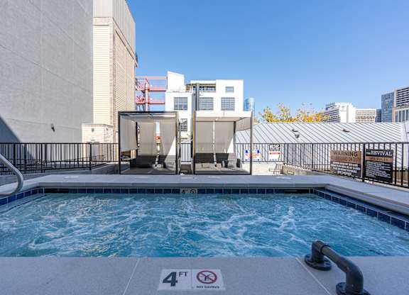 a swimming pool with a hot tub and a building in the background at The Revival, Utah, 84101