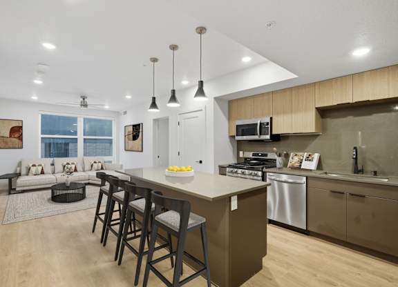Modern kitchen with large island and bar stools at Brickside Heights, Millcreek, UT, 84106