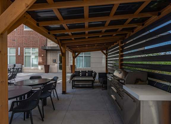 a covered patio with a grill and tables and chairs at 200 City View, Provo, UT, 84601