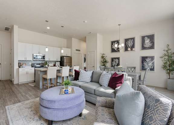 an open living room and kitchen with a couch and a table at 200 City View, Provo, 84601