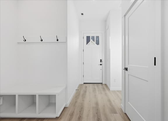 Hallway with a bench and three hooks on the wall at Alante Homes at Spring Run, Caldwell, 83607