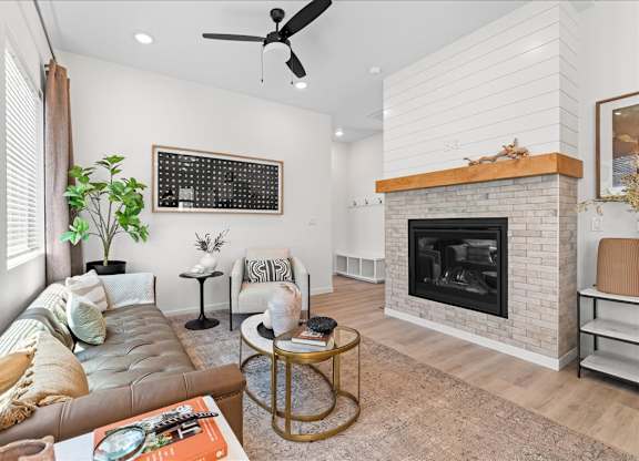 A living room with a fireplace and a couch.at Alante Homes at Spring Run, Caldwell, ID 83607