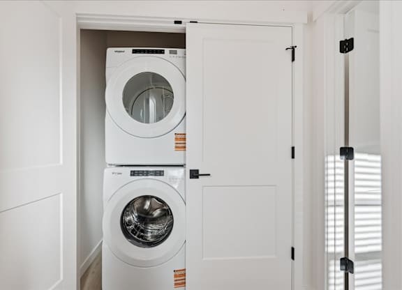 Small Laundry room with stacked washer and dryer at Alante Homes at Spring Run, Caldwell