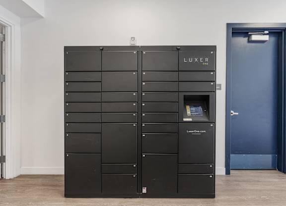 a set of black lockers in a room with a blue door at 605 Place Student Housing & Co-Living, St George, Utah