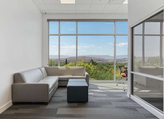 a living room with a couch and a coffee table in front of large windows at 605 Place Student Housing & Co-Living, St George