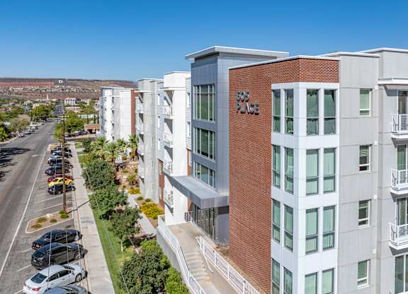 A modern apartment building with a parking lot in front. 605 Place Student Housing & Co-Living, St George, UT 84770
