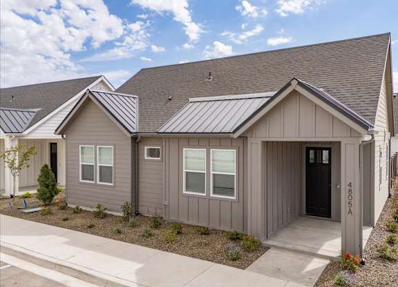 A grey house with a black door and windows. at Alante Homes at Spring Run, Caldwell, Idaho