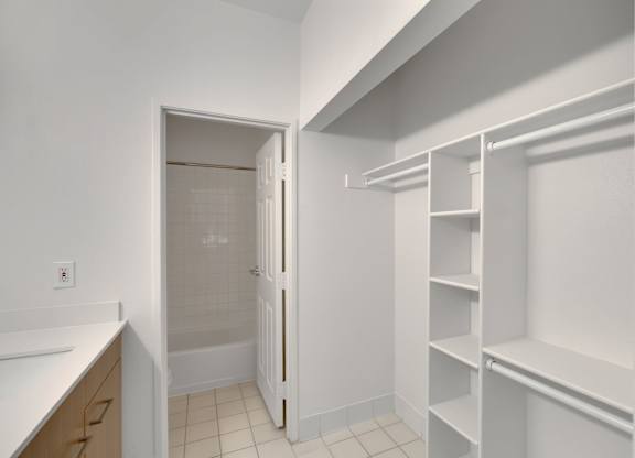 Walk in closet with white shelving at AVIA Apartments On Alpha, Dallas, TX