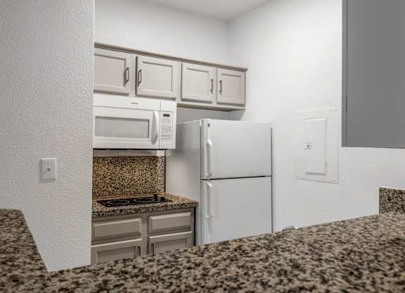 Kitchen with white appliances at AVIA Apartments On Alpha, Texas