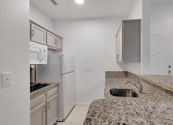 Kitchen with granite countertop at AVIA Apartments On Alpha, Dallas, TX, 75240