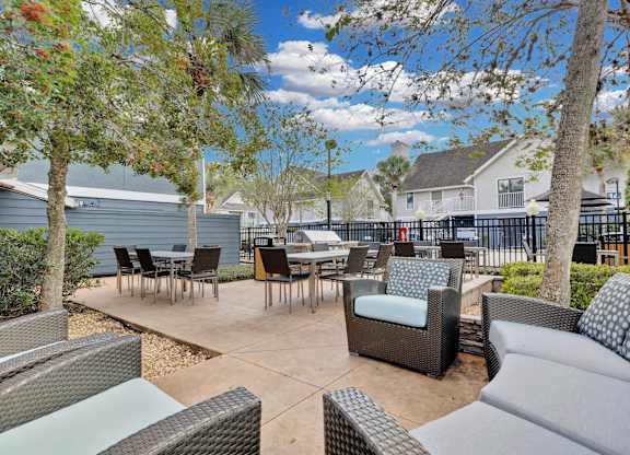 A patio with a table and chairs surrounded by trees.