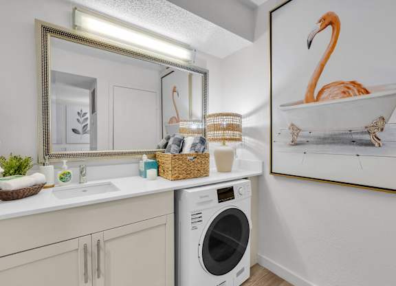 a laundry room with a sink and a washing machine and a mirror and a tub at AVIA Lofts on Liberty Ridge Apartments, Jacksonville, FL, 32256