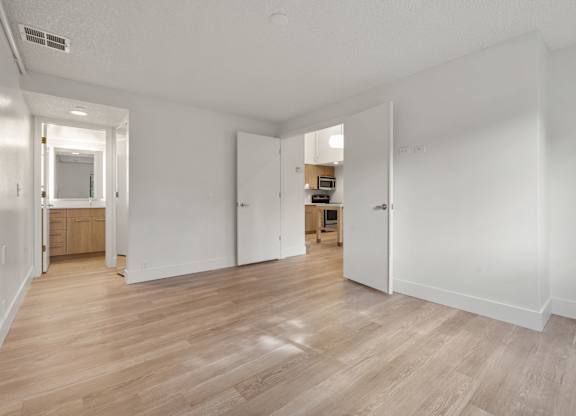 a living room and kitchen with wood floors and white walls at AVIA Lofts on Parkway Apartments, Washington, 98662