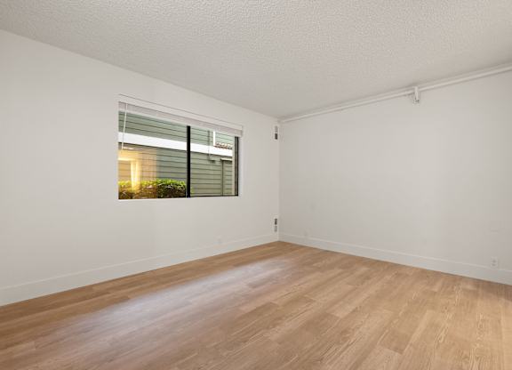 a spacious living room with a window and wood flooring at AVIA Lofts on Parkway Apartments, Vancouver, WA