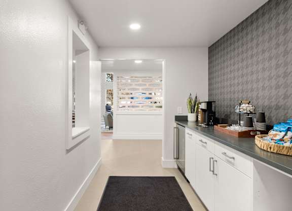 a kitchen with white cabinets and a counter top and a door to a store at AVIA Lofts on Parkway Apartments, Vancouver, 98662