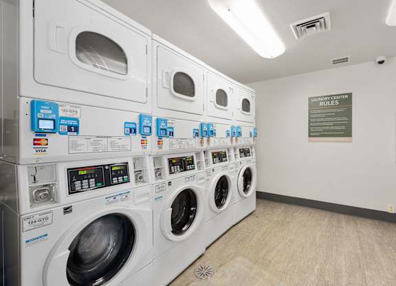 a washer and dryer machine in a laundry room with other washing machines at AVIA Lofts on Parkway Apartments, Washington, 98662
