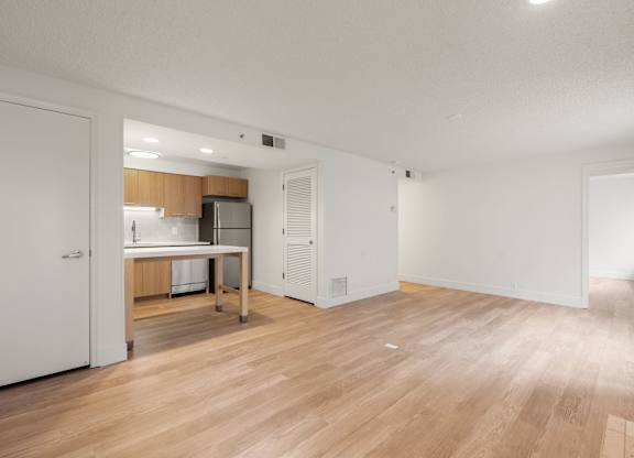 the living room and kitchen of an apartment with a hardwood floor and a kitchen at AVIA Lofts on Parkway Apartments, Vancouver, WA, 98662