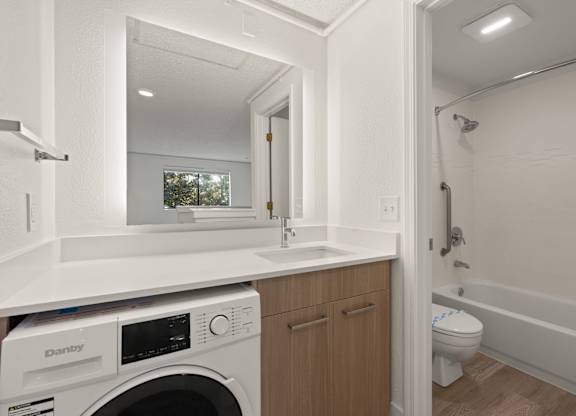 a laundry room with a sink and a washer and dryer in a house at AVIA Lofts on Parkway Apartments, Vancouver, WA