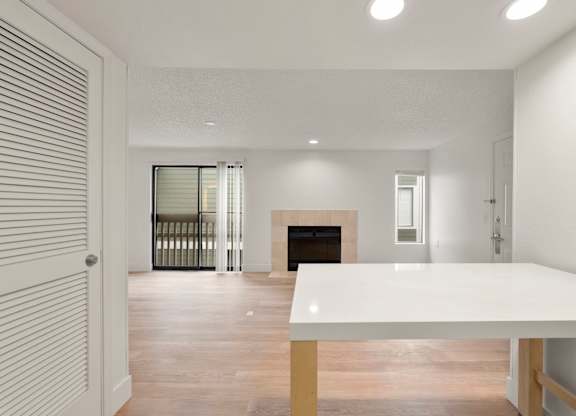 the living room and dining room of a house with a white table and a fireplace at AVIA Lofts on Parkway Apartments, Washington, 98662