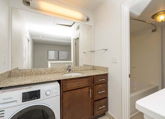 Bathroom with a sink and a washer and dryer at AVIA Lofts on Victors Way, Michigan , 48108