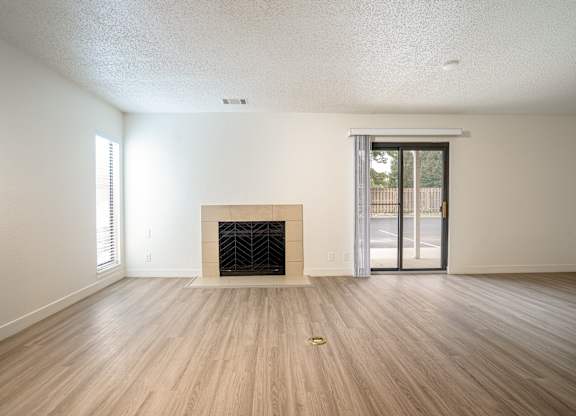 Living room with a fireplace and sliding glass doors at AVIA Lofts on Victors Way, Ann Arbor, 48108