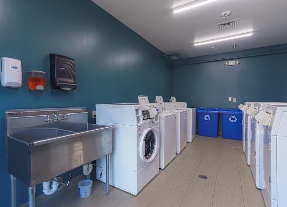 a laundry room with washes and washing machines and a sink at AVIA Lofts on Victors Way, Michigan , 48108