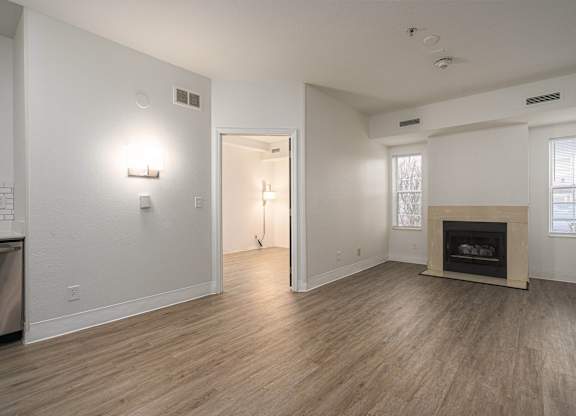 Large living room with a fireplace and wood flooring at AVIA Lofts on Victors Way, Ann Arbor, 48108