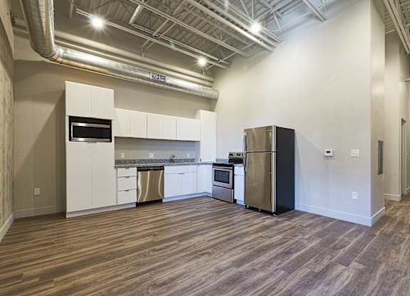 A kitchen with white cabinets and a black refrigerator at Brickside Heights Apartments, Utah, 84106