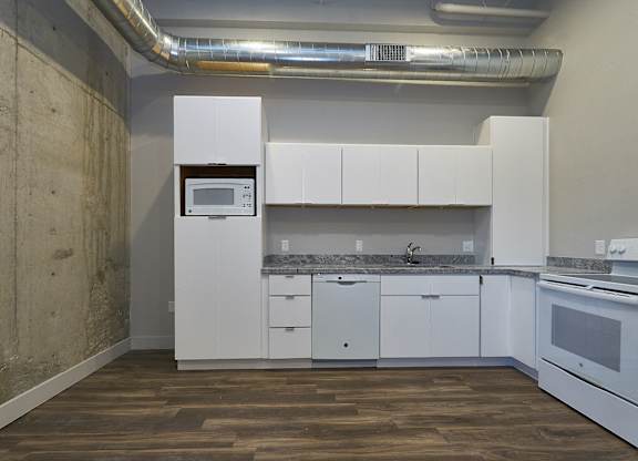 A kitchen with white cabinets and a white oven at Brickside Heights Apartments, Millcreek, Utah