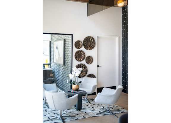 A white chair is in front of a wall with circular decorations.
