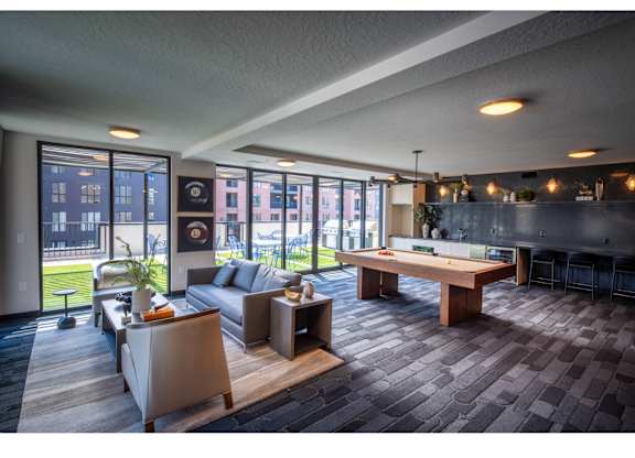 A modern living room with a pool table and a view of the city.