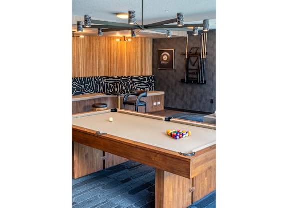 A pool table with a white ball and a striped cue ball on it.