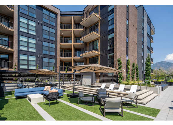 A modern apartment complex with a well-maintained outdoor seating area.