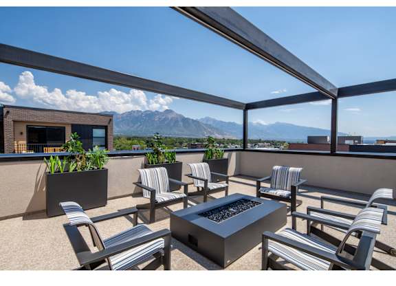 A patio with a table and chairs overlooking a mountain range.