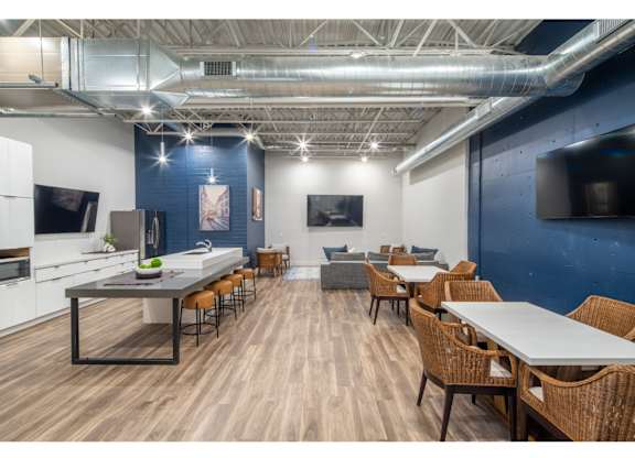A modern kitchen and dining area with wooden floors and furniture.