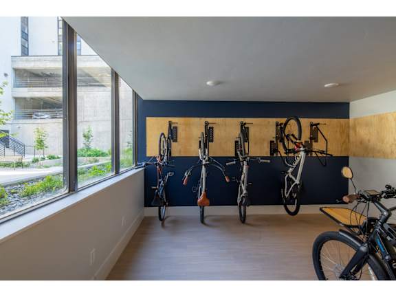 A bike room with bikes on the wall and a window.