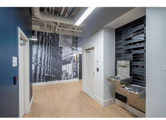 A kitchen area with a sink and a wall mural.