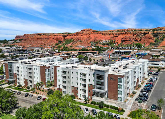 an aerial view of apartment buildings with red cliffs in the background at 605 Place Student Housing & Co-Living, St George, UT, 84770